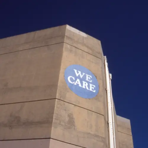 Sticker saying 'We care' on a building.